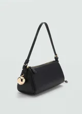 Bolso negro tipo baguette con correa de hombro fina y charm dorado en forma de esfera.
