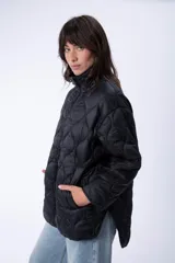 Campera de abrigo capitoneada color negro, con cierre frontal y bolsillos laterales.