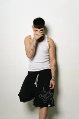 Bermuda negra de algodón con corte oversize y logo trigrama bordado en blanco en la pierna derecha.