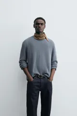 Sweater azul de punto con textura, corte holgado, cuello redondo y mangas largas con puños acanalados.
