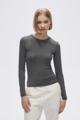 Remera gris de poliéster, de manga larga, corte ajustado y cuello redondo.