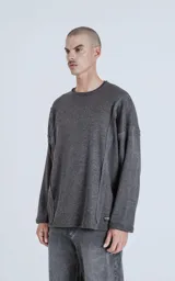 Sweater gris oscuro de corte recto, cuello redondo y mangas largas con detalle de costuras a los lados.