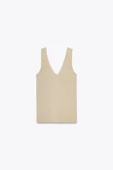 Top de punto color beige, con escote en pico y sisas anchas.