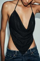 Top negro con escote drapeado y tiras finas ajustables en cuello y espalda. Detalle de aplicación de abalorios.