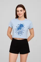 Remera cropped celeste con estampado de medusa azul y texto "Deep Blue".