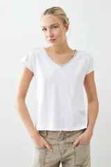 Remera blanca de algodón con escote en V y bordado en el borde. De corte recto y mangas cortas.