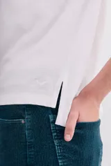 Remera blanca de algodón peruano, de corte ajustado y escote en V pronunciado.