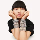 Pulsera rígida plateada con cristales transparentes de talla triangular engarzados en hilera.