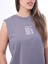 Remera sin mangas, color gris lila, de corte cropped y cuello redondo. Estampado frontal con texto que dice "BORN IN THE 90'S".