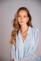 Camisa blanca de plumetí con cuello mao, mangas largas abullonadas con puños elásticos y cordón con borlas en el escote.
